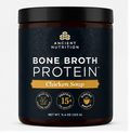A dark amber plastic tub of Ancient Nutrition Bone Broth Protein Chicken Soup with a black lid and a dark navy label featuring white and gold text.
