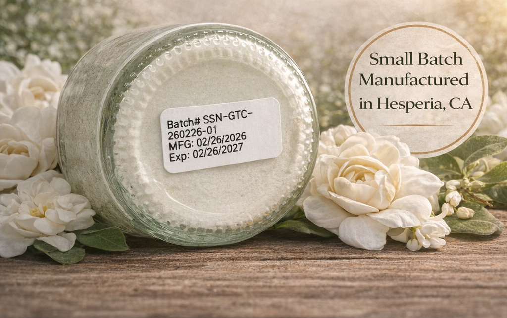 Jar with a label on a wooden surface surrounded by white flowers