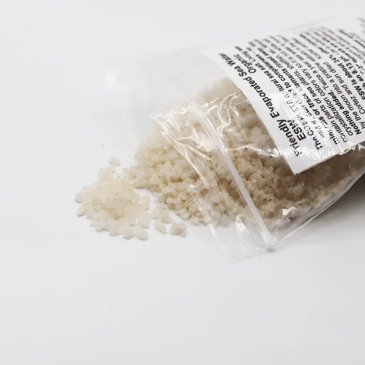 Clear container with beige granules and a label on a white background
