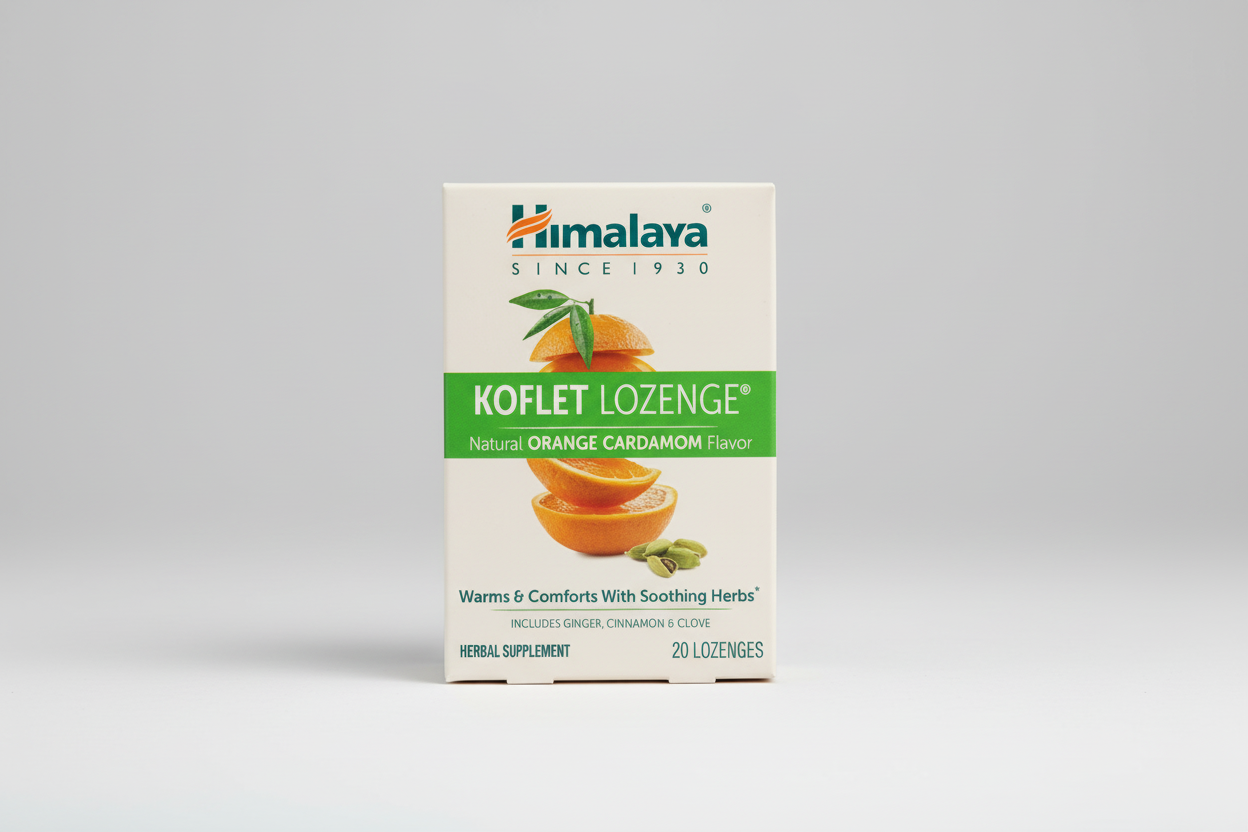 Himalaya Koflet Lozenge packaging with oranges and cardamom on a beige background