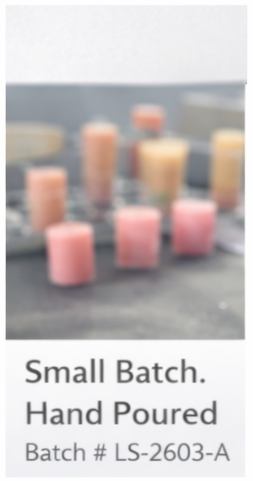 Small batch hand-poured candles on a gray surface with text indicating batch number.