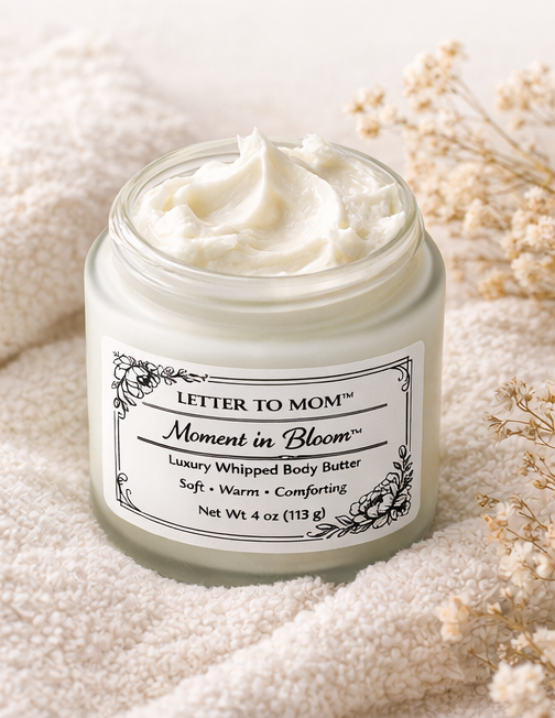 Jar of 'Moment in Bloom' luxury whipped body butter on a soft fabric background