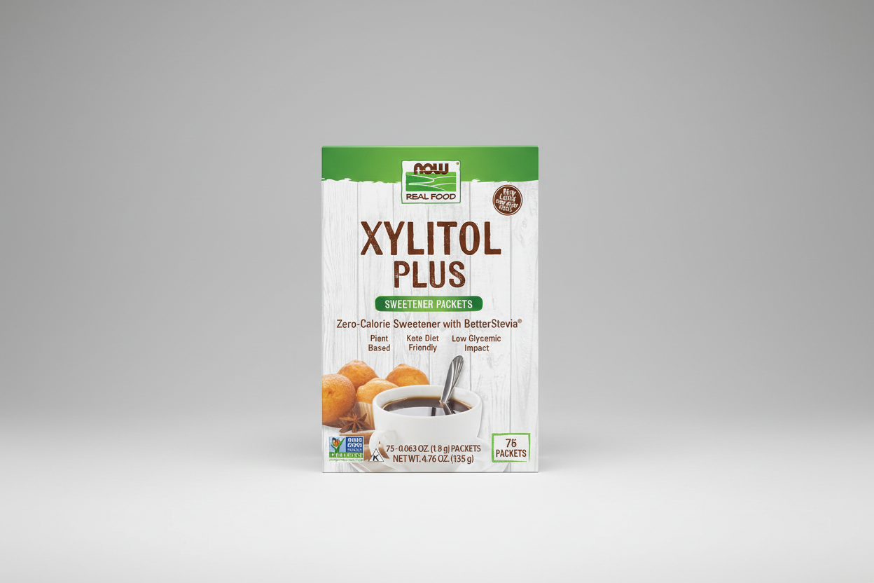 Package of Xylitol Plus sweetener packets with a cup of coffee and cookies on a white background.