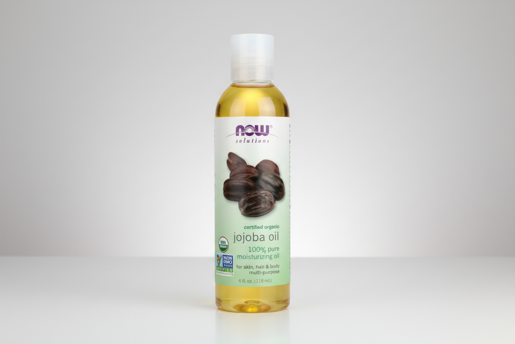 Bottle of NOW Solutions jojoba oil on a white background