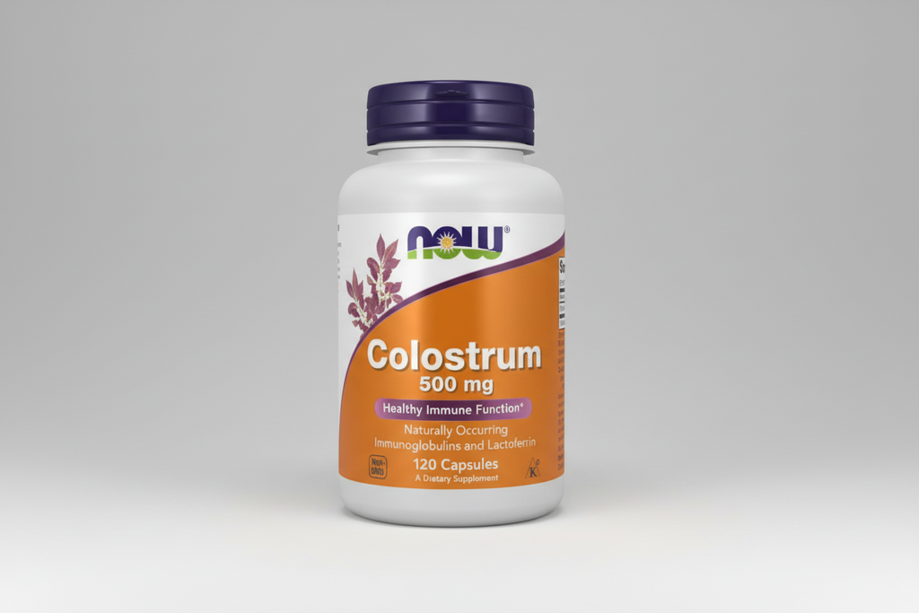 Vitamin supplement bottle labeled 'Colostrum 500 mg' with NOW brand on an orange and purple background.
