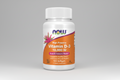 Supplement bottle of Vitamin D-3 with Now brand on an orange and white background