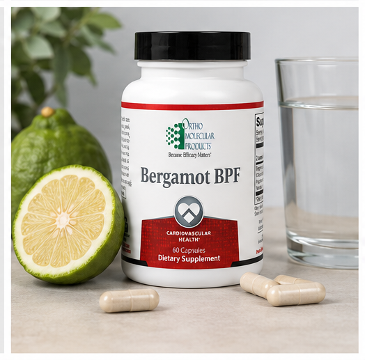 A white bottle of Ortho Molecular Products Bergamot BPF dietary supplement with a black cap, shown on a light surface with a glass of water, loose capsules, and bergamot fruit.