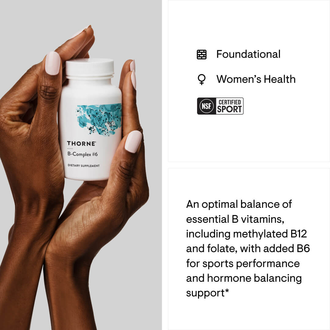 Hand holding a Thorne B-Complex supplement bottle with product details on a light gray background