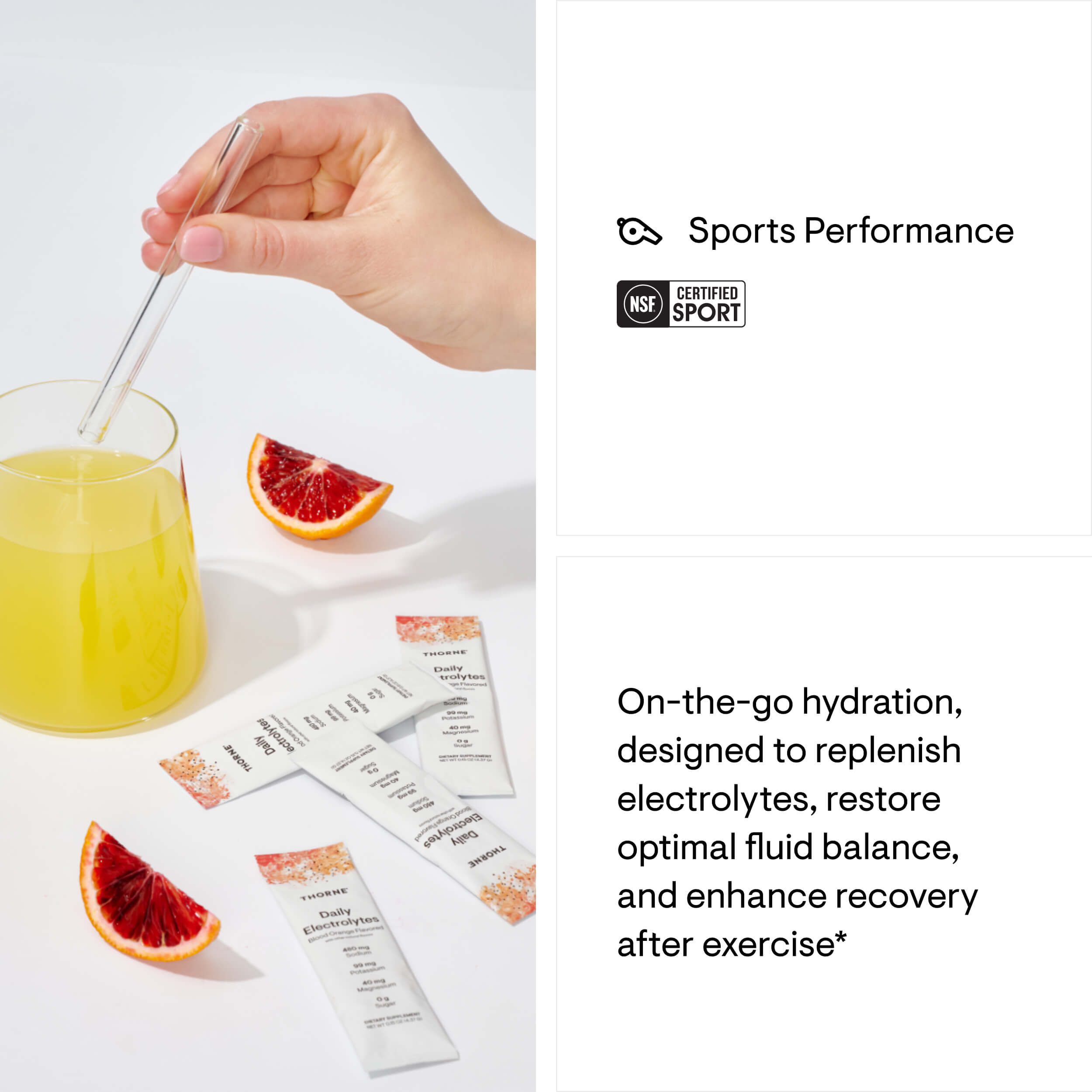 Hand stirring a glass of juice with sports performance drink packets and blood orange slices on a white background.