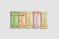 Hands holding various flavors of 'The Only Bar' with a pool background and USDA Organic logo.