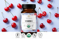 Truvani Vitamin C supplement bottle with organic certification on a background of cherries